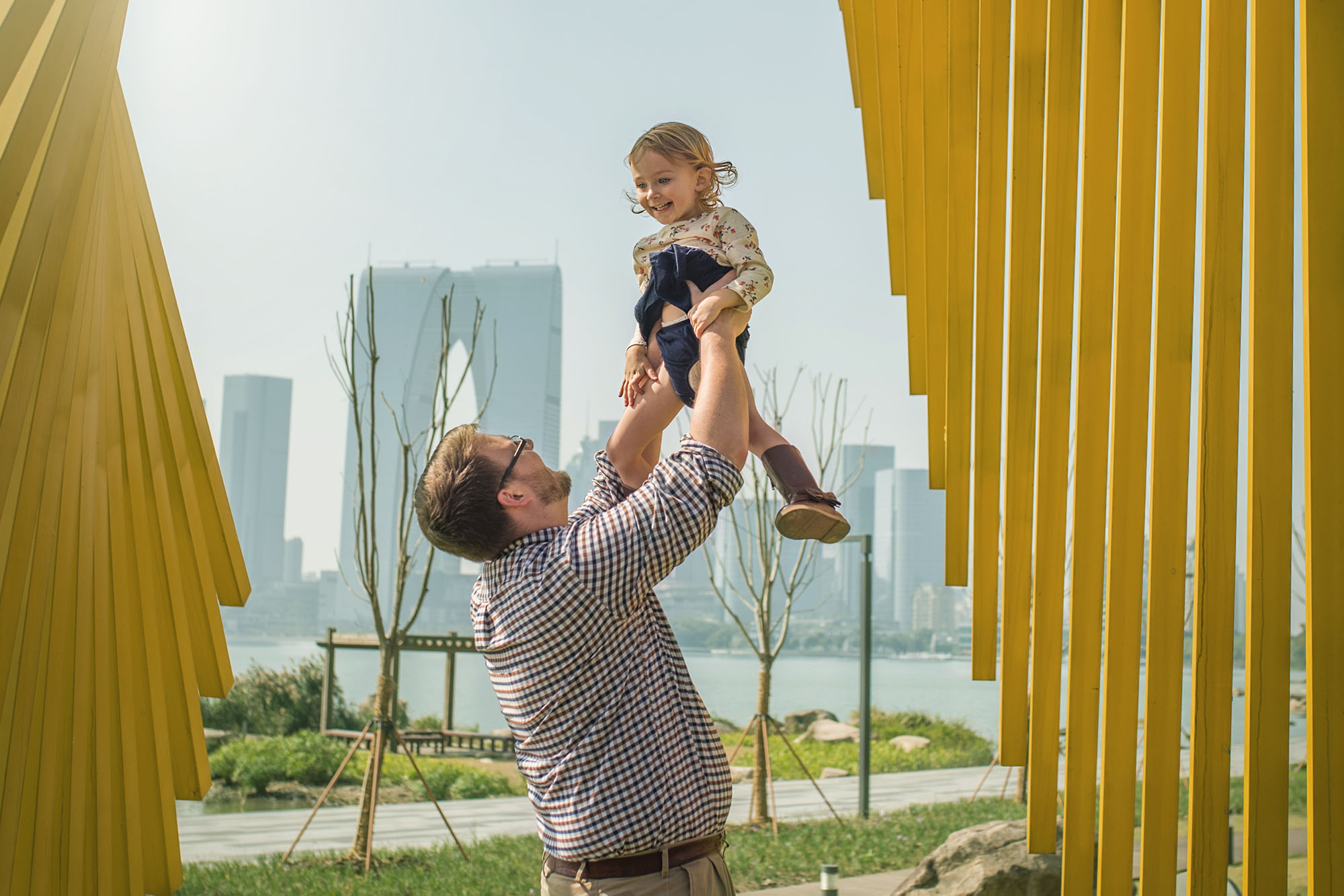 Father and young daughter sharing a playful moment during a natural outdoor family photography session
