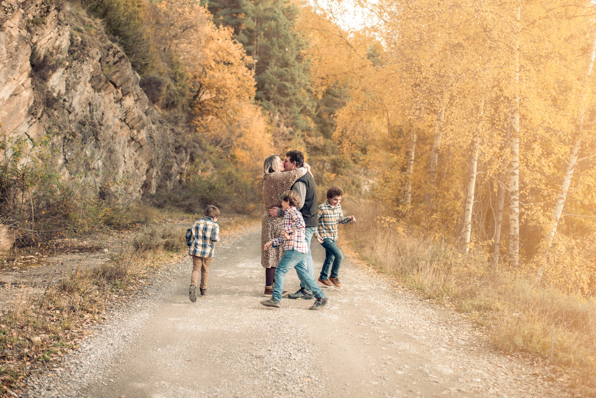 Family interacting naturally in autumn landscape with warm light