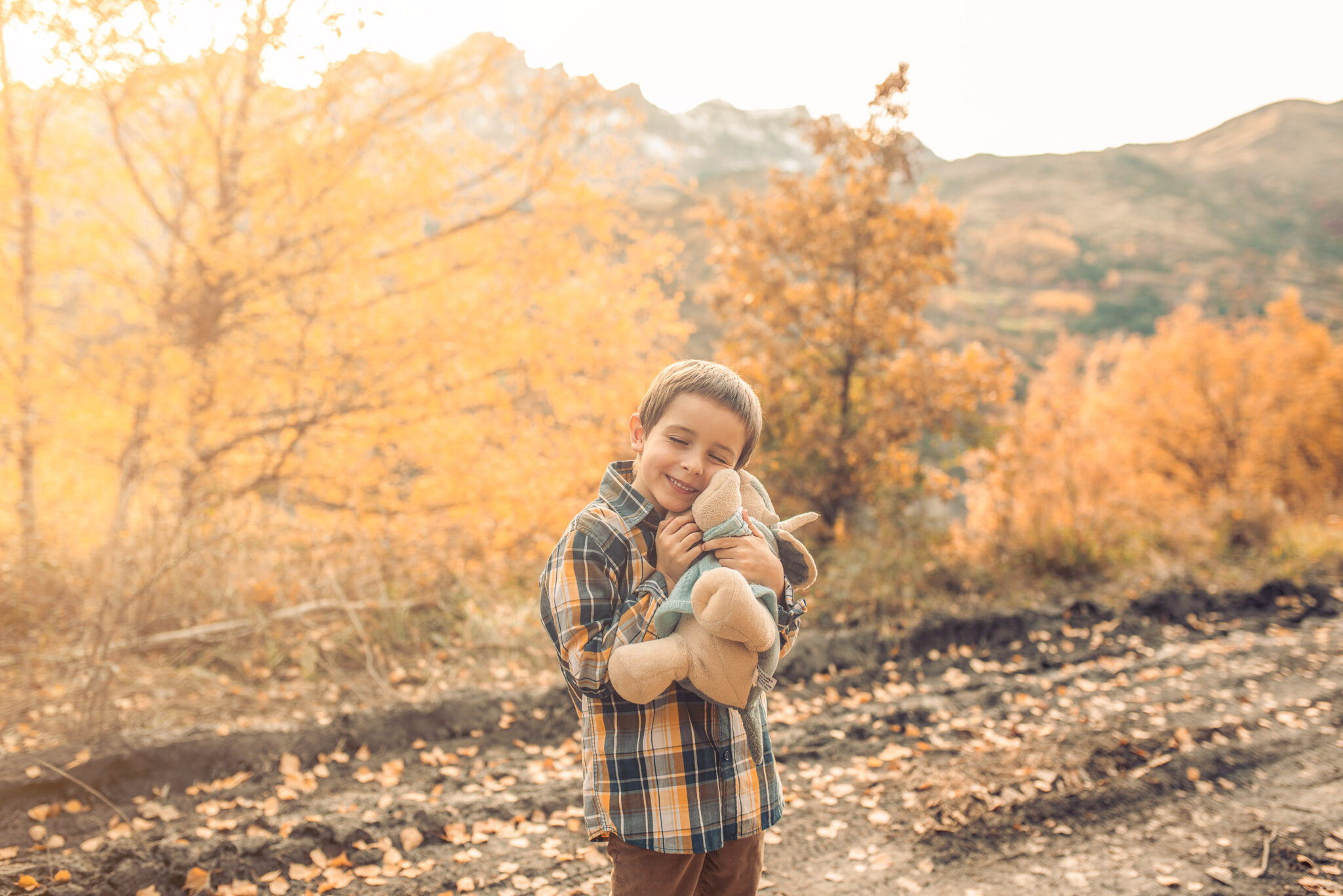 Child portrait in autumn holding a toy with warm natural light