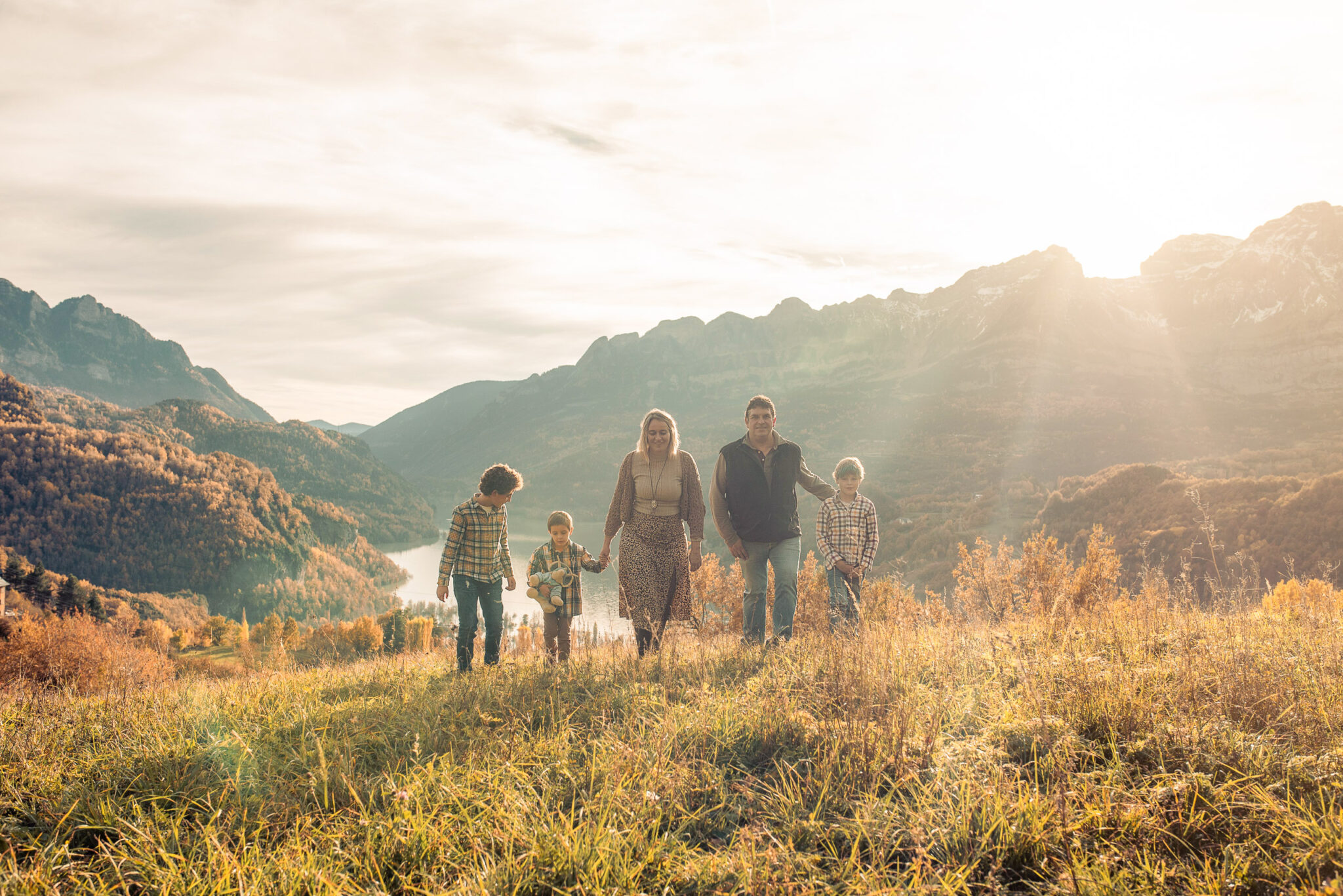 Family walking in the mountains during golden hour in autumn